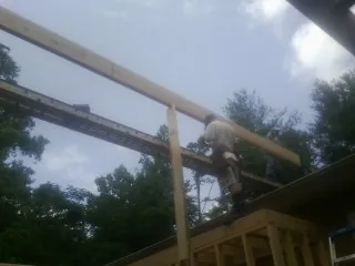Carpenter setting a ridge beam over a new addition frame — Ice Dam Removal by Roofing Brothers in North Easton