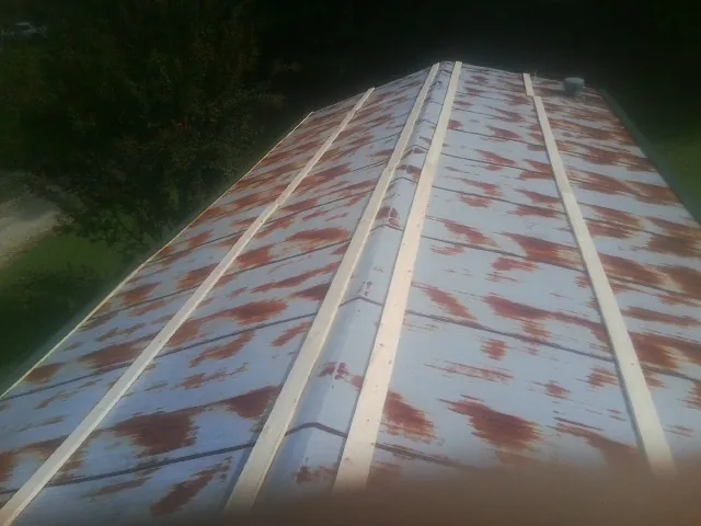 Rusted metal roof panels with new wood purlins before replacement — Storm Damage Roof Repair in North Easton by Roofing Brothers