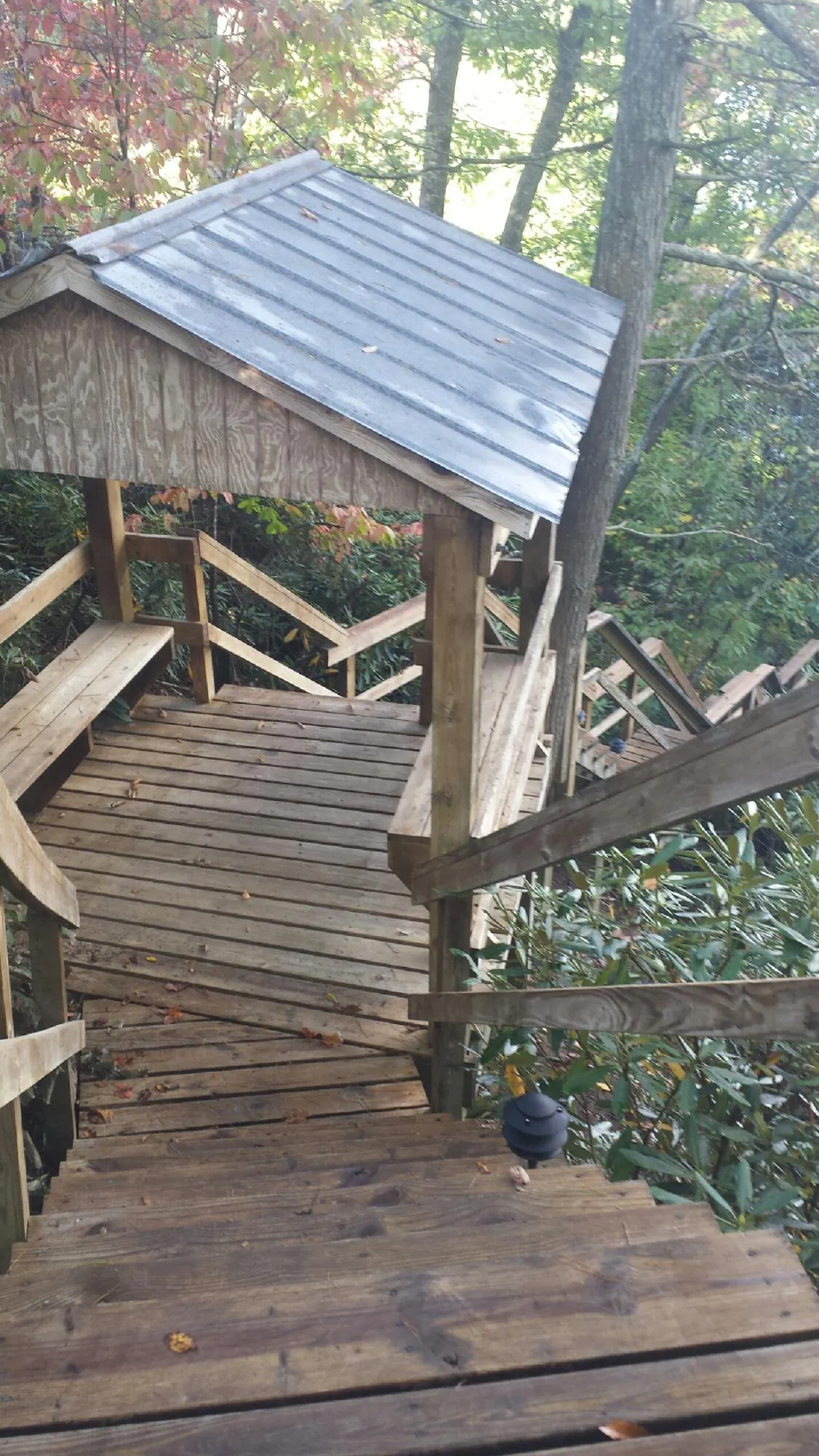 Metal roofed shelter over wooden steps on a wooded walkway — Skylight Repair & Installation work by our crew in North Easton