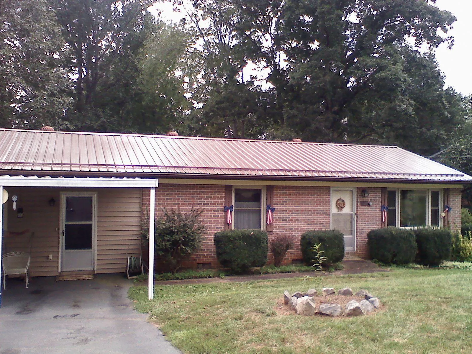 Bronze metal roof and carport on a brick ranch home — Roof Repair work by our crew in North Easton